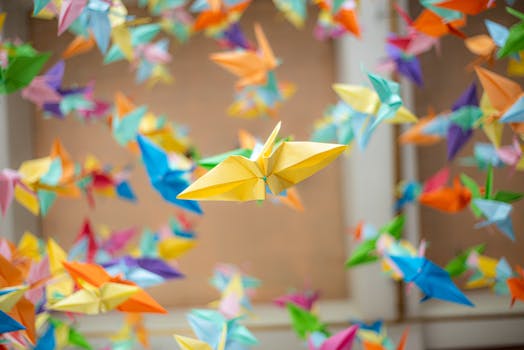 Colorful origami cranes hanging indoors, creating a lively and artistic ambiance.